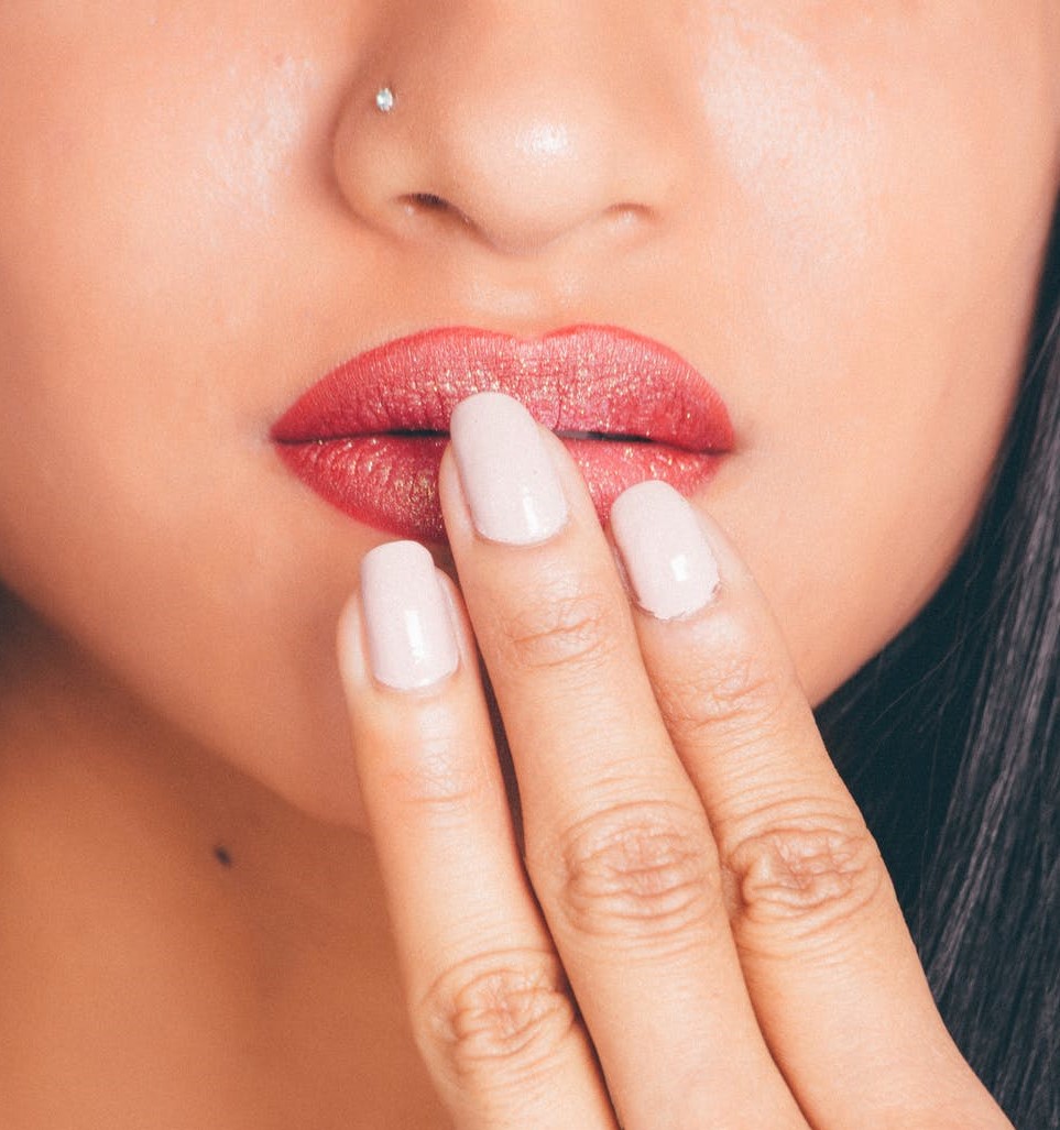 Photo d'ongles en gel devant une bouche